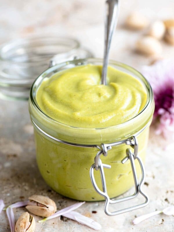 A jar of pistachio cream with a spoon in it